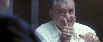 Movie still from “Demonlover” (2002), directed by Olivier Assayas – An older man is holding a pen in his hand; Close Up shot, Low angle