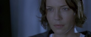 Movie still from “Demonlover” (2002), directed by Olivier Assayas – A woman's face in the dark; Close Up shot, Over the shoulder angle