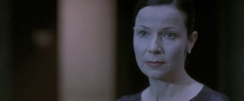 Movie still from “Demonlover” (2002), directed by Olivier Assayas – A woman's face in front of a mirror; Close Up shot, Over the shoulder angle