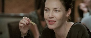 Movie still from “Demonlover” (2002), directed by Olivier Assayas – A person holding food in their hand; Close Up shot, Over the shoulder angle