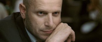 Movie still from “Demonlover” (2002), directed by Olivier Assayas – A person with his hand under his chin; Close Up shot, Low angle