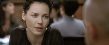 Movie still from “Demonlover” (2002), directed by Olivier Assayas – A person sitting at a table; Close Up shot, Over the shoulder angle