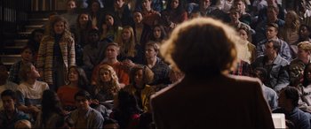Movie still from “Denial” (2016), directed by Mick Jackson – A group of people sitting in a room with a woman; Wide shot, High angle