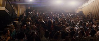 Movie still from “Denial” (2016), directed by Mick Jackson – A crowd of people sitting and standing in a room; Extreme Wide shot, High angle