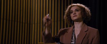 Movie still from “Denial” (2016), directed by Mick Jackson – A woman sitting in front of a wall holding a pair of scissors in her hand; Close Up shot, Low angle