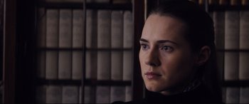 Movie still from “Denial” (2016), directed by Mick Jackson – A person in front of a book case; Close Up shot, Over the shoulder angle