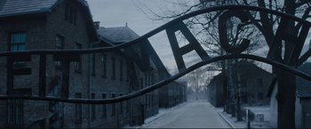 Movie still from “Denial” (2016), directed by Mick Jackson – A view of a street from a gate; Extreme Wide shot, High angle