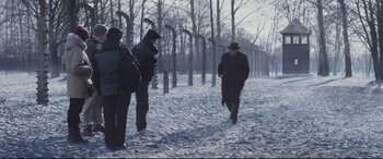 Movie still from “Denial” (2016), directed by Mick Jackson – A group of people walking in the snow near trees; Wide shot, Over the shoulder angle