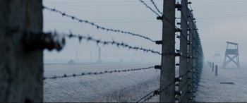Movie still from “Denial” (2016), directed by Mick Jackson – A barbed wire fence in front of a body of water; Extreme Wide shot, High angle