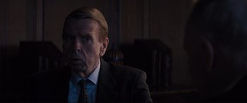 Movie still from “Denial” (2016), directed by Mick Jackson – A person wearing a suit and tie; Close Up shot, Over the shoulder angle