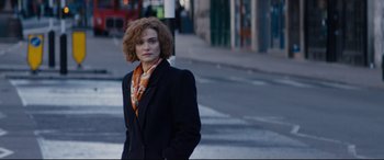 Movie still from “Denial” (2016), directed by Mick Jackson – A woman standing on the side of the street; Medium shot, Low angle