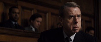 Movie still from “Denial” (2016), directed by Mick Jackson – A man in a suit and tie in front of a mirror; Close Up shot, Over the shoulder angle