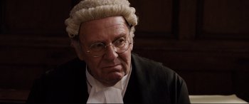 Movie still from “Denial” (2016), directed by Mick Jackson – An old man wearing a judge's wig and glasses; Close Up shot, Over the shoulder angle