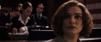 Movie still from “Denial” (2016), directed by Mick Jackson – A woman sitting in front of two other people; Close Up shot, Over the shoulder angle