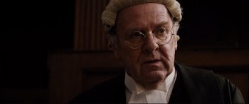 Movie still from “Denial” (2016), directed by Mick Jackson – An old man wearing a judge's wig in a courtroom; Close Up shot, Over the shoulder angle