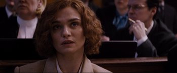 Movie still from “Denial” (2016), directed by Mick Jackson – A person sitting in front of some people; Close Up shot, Over the shoulder angle