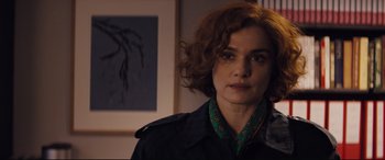 Movie still from “Denial” (2016), directed by Mick Jackson – A person with curly hair; Close Up shot, Over the shoulder angle