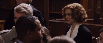 Movie still from “Denial” (2016), directed by Mick Jackson – A woman in black jacket standing in front of a crowd of people; Close Up shot, Over the shoulder angle