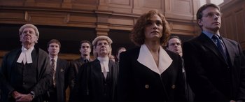 Movie still from “Denial” (2016), directed by Mick Jackson – A group of people standing in front of each other; Medium shot, Low angle