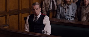 Movie still from “Denial” (2016), directed by Mick Jackson – A man sitting in front of a judge in a courtroom; Medium shot, Over the shoulder angle