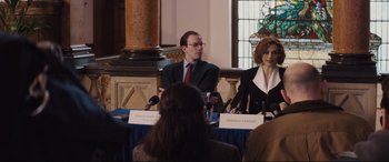 Movie still from “Denial” (2016), directed by Mick Jackson – A man and a woman sitting in front of microphones; Medium shot, Over the shoulder angle