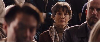 Movie still from “Denial” (2016), directed by Mick Jackson – An older woman is sitting in a crowd of people; Close Up shot, Over the shoulder angle