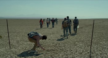 Movie still from “Desierto” (2015), directed by Jonás Cuarón – A group of people walking across a dry field; Wide shot, Low angle