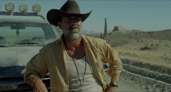 Movie still from “Desierto” (2015), directed by Jonás Cuarón – A man in a cowboy hat sitting on the hood of a truck; Medium shot, Over the shoulder angle