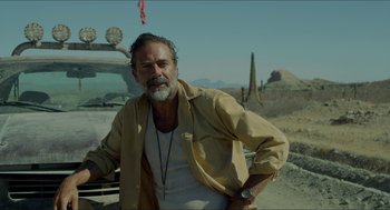 Movie still from “Desierto” (2015), directed by Jonás Cuarón – A man standing next to a car on a dirt road; Medium shot, Over the shoulder angle