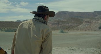 Movie still from “Desierto” (2015), directed by Jonás Cuarón – A man wearing a cowboy hat looking out over a desert; Medium shot, Over the shoulder angle