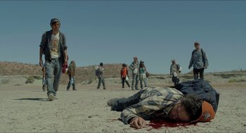 Movie still from “Desierto” (2015), directed by Jonás Cuarón – A group of people walking around a dead body on the ground; Wide shot, High angle