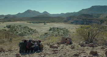 Movie still from “Desierto” (2015), directed by Jonás Cuarón – A group of people standing on top of a rocky hill; Extreme Wide shot, High angle