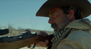 Movie still from “Desierto” (2015), directed by Jonás Cuarón – A man with a beard holding a rifle in his hand; Close Up shot, Over the shoulder angle