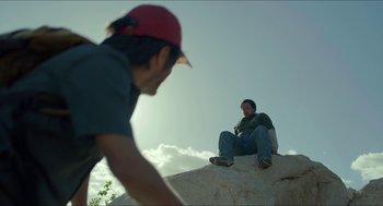 Movie still from “Desierto” (2015), directed by Jonás Cuarón – A man and a woman sitting on top of a rock; Wide shot, Low angle