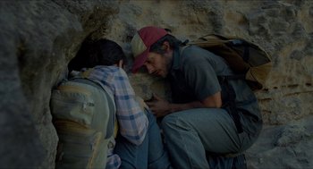 Movie still from “Desierto” (2015), directed by Jonás Cuarón – A man and a woman sitting next to each other on the ground; Medium shot, Overhead angle