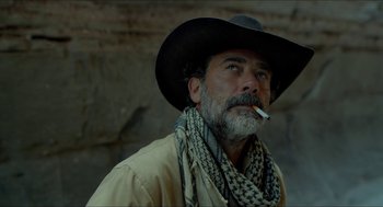 Movie still from “Desierto” (2015), directed by Jonás Cuarón – A man in a cowboy hat smoking a cigarette in front of a stone wall; Close Up shot, Over the shoulder angle