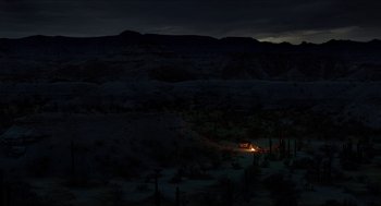 Movie still from “Desierto” (2015), directed by Jonás Cuarón – A fire in the dark in the middle of the night; Extreme Wide shot, High angle