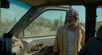 Movie still from “Desierto” (2015), directed by Jonás Cuarón – A man standing in the driver's seat of a car; Medium shot, Over the shoulder angle