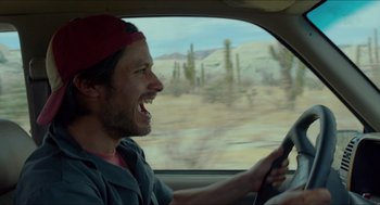 Movie still from “Desierto” (2015), directed by Jonás Cuarón – A man driving a car in the middle of the day; Close Up shot, Low angle