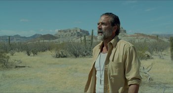 Movie still from “Desierto” (2015), directed by Jonás Cuarón – A man with a beard is standing in the desert; Medium shot, Over the shoulder angle