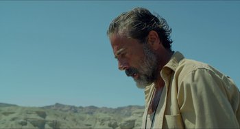 Movie still from “Desierto” (2015), directed by Jonás Cuarón – A man with a gray beard is standing in the desert; Close Up shot, Over the shoulder angle
