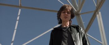 Movie still from “Destroyer” (2018), directed by Karyn Kusama – A person standing in front of a metal structure; Medium shot, Low angle