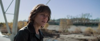 Movie still from “Destroyer” (2018), directed by Karyn Kusama – A woman with long brown hair is standing in the dirt; Close Up shot, Low angle