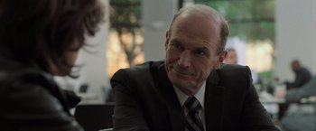 Movie still from “Destroyer” (2018), directed by Karyn Kusama – A man in a suit and tie sitting down; Close Up shot, Over the shoulder angle