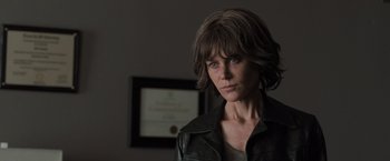 Movie still from “Destroyer” (2018), directed by Karyn Kusama – A woman in a leather jacket is looking at the camera; Close Up shot, Over the shoulder angle