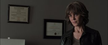 Movie still from “Destroyer” (2018), directed by Karyn Kusama – A woman in a leather jacket standing in front of a certificate; Close Up shot, Over the shoulder angle