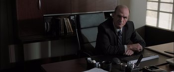 Movie still from “Destroyer” (2018), directed by Karyn Kusama – A man sitting at a desk in front of a computer; Medium shot, Over the shoulder angle