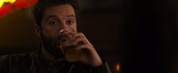 Movie still from “Destroyer” (2018), directed by Karyn Kusama – A person holding a glass of beer; Close Up shot, High angle