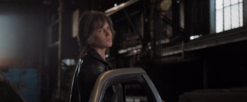 Movie still from “Destroyer” (2018), directed by Karyn Kusama – A man in a leather jacket holding onto a car; Medium shot, Low angle