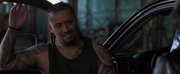 Movie still from “Destroyer” (2018), directed by Karyn Kusama – A man with dreadlocks sitting in front of a car; Close Up shot, Over the shoulder angle